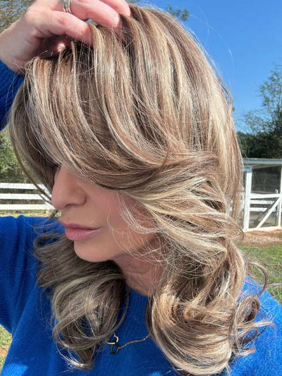 Emily H. @she_sheds_more wearing CAROLINE by BELLETRESS in color SUNKISSED ALMOND R | A blend of Medium and Light Brown with Light Gold Blonde Highlights and a hint of Cooler Blonde, rooted with Medium and Light Brown | direct sunlight